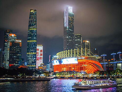 Guangzhou Stadium illuminated at night, showcasing its modern architecture and vibrant atmosphere during a sports event.