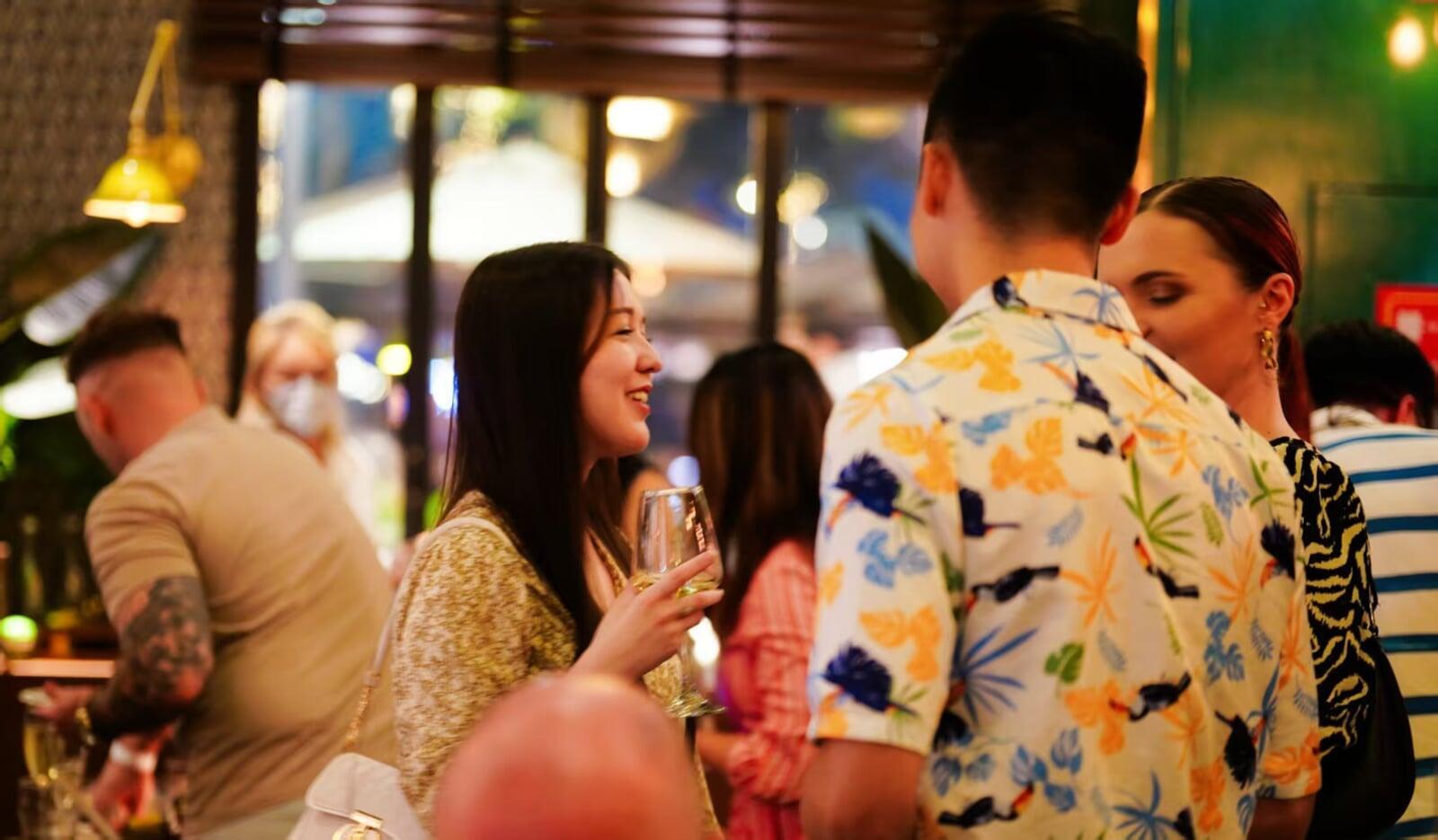 Vibrant nightlife scene at The Embassy Bar in Guangzhou, with people enjoying drinks and socializing in a lively atmosphere.